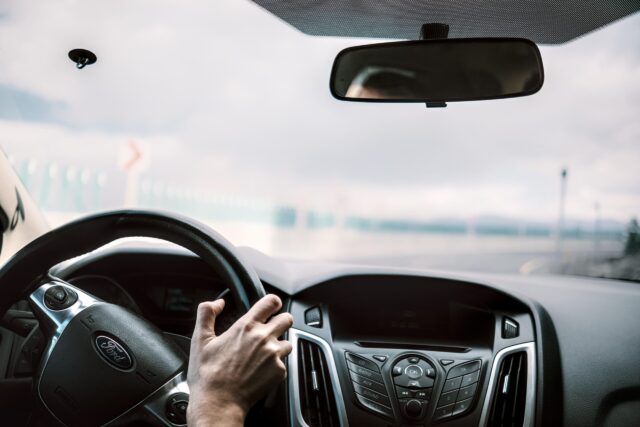 Widok z wnętrza samochodu marki Ford podczas jazdy drogą.