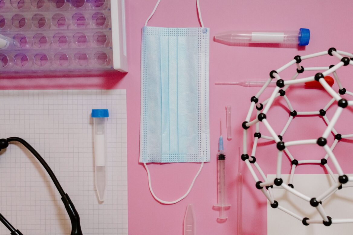 Sprzęt medyczny i laboratoryjny na różowym tle.