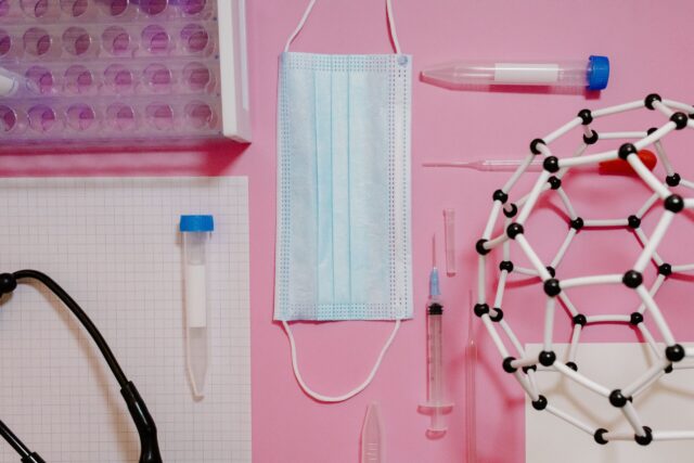 Sprzęt medyczny i laboratoryjny na różowym tle.
